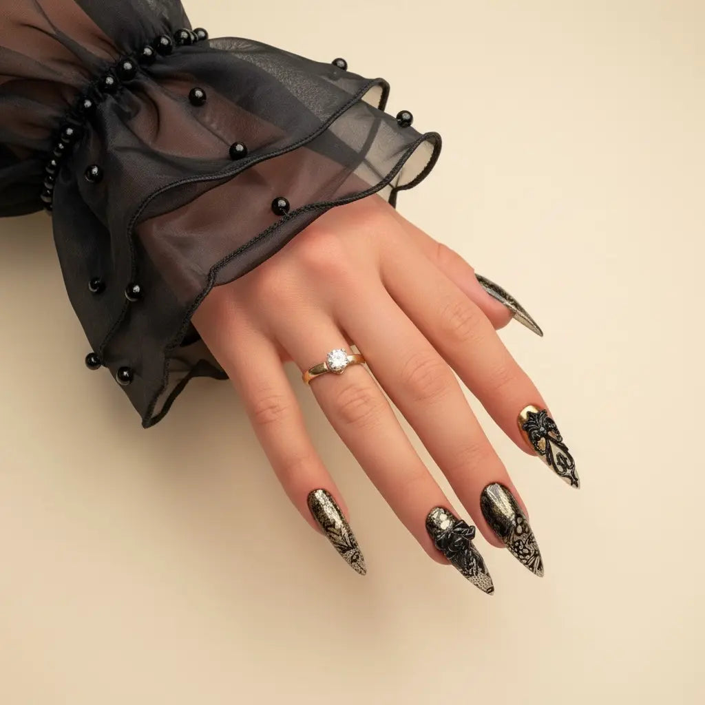 Black stiletto press-on nails with glossy chrome finish and sculpted metallic details in a bold statement nail design.