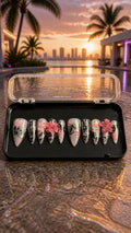 Handmade luxury press-on nails featuring silver chrome, black lace nail art, hand-painted pink cherry blossoms, 3D floral accents, glossy finish, and long stiletto shape.