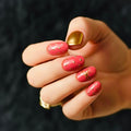 Short round dry rose pink press-on nails with gold stud accents and one metallic gold accent nail.