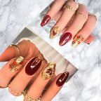 Luxury burgundy and gold press-on nails with heart accents and high-gloss finish on round-shaped nails.
