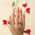 
Luxury stiletto press-on nails in vibrant coral red with gold detailing and a crystal accent nail, handcrafted with a glossy gel finish from the At Sunset Collection.