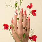 
Luxury stiletto press-on nails in vibrant coral red with gold detailing and a crystal accent nail, handcrafted with a glossy gel finish from the At Sunset Collection.