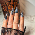 Midnight Web black and silver stiletto press-on nails displayed in case