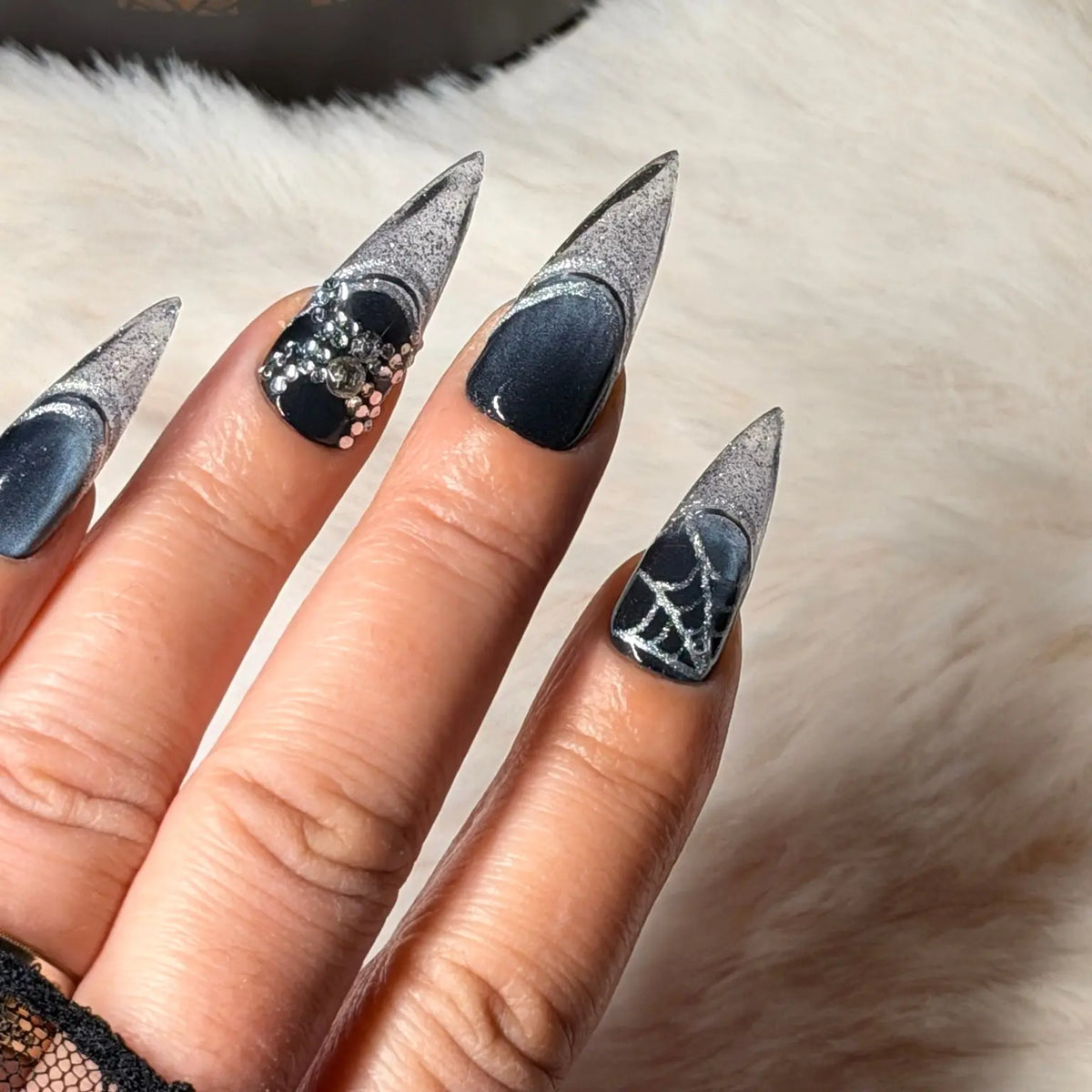 Hand wearing Midnight Web smoky silver glitter and crystal stiletto nails