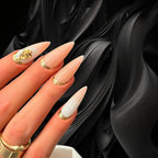 Press to Impress Antigua luxury press-on nails with champagne shimmer, ivory accents, and gold glitter embellishments.