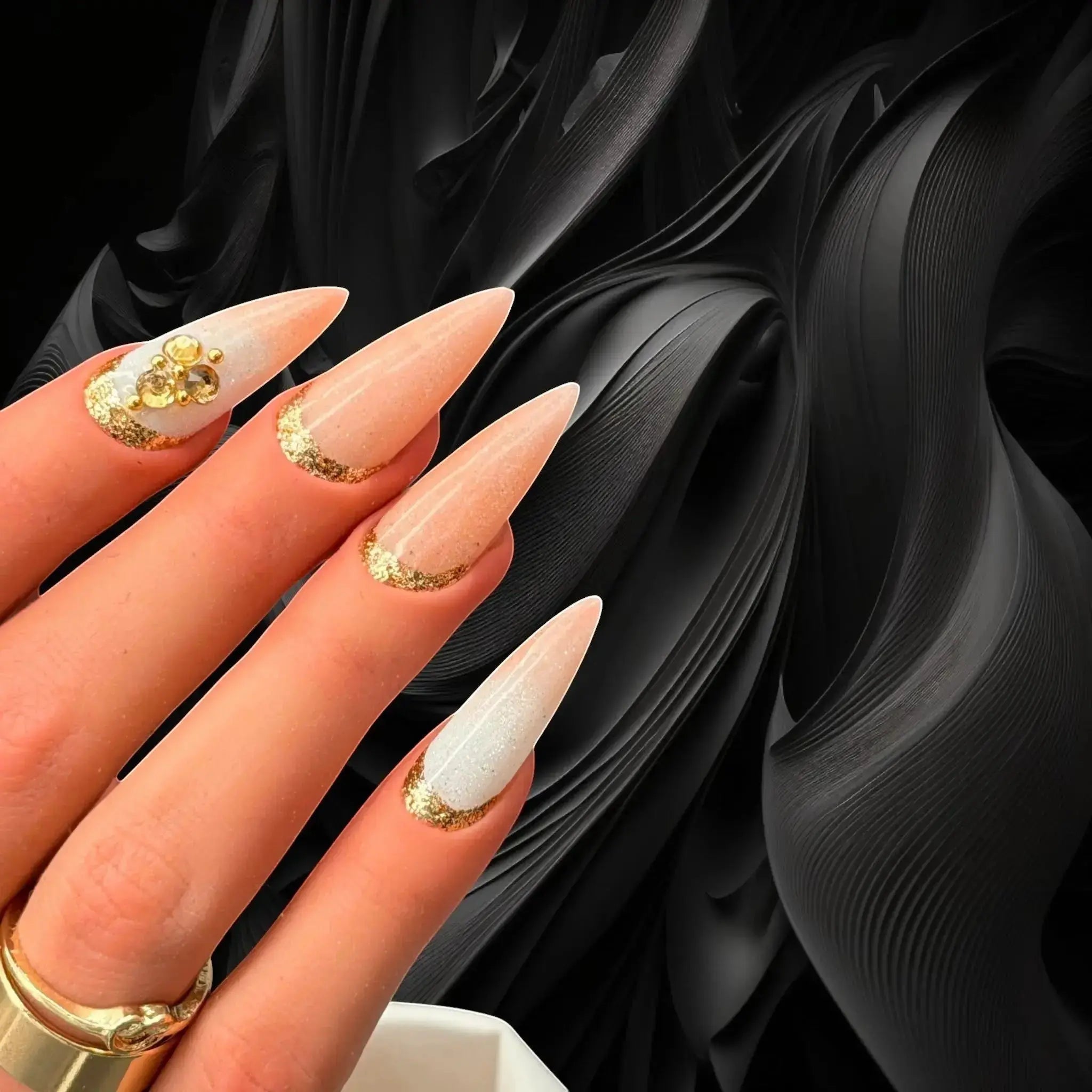 Press to Impress Antigua luxury press-on nails with champagne shimmer, ivory accents, and gold glitter embellishments.