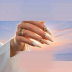 Press to Impress Antigua luxury press-on nails with champagne shimmer, gold glitter, and embellishments at sunset.