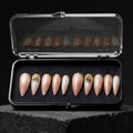 Press to Impress Antigua luxury press-on nails with champagne shimmer, ivory accents, and gold glitter embellishments.