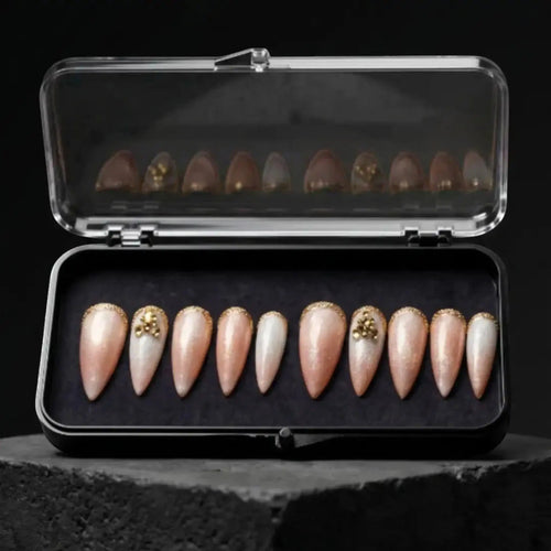 Press to Impress Antigua luxury press-on nails with champagne shimmer, ivory accents, and gold glitter embellishments.