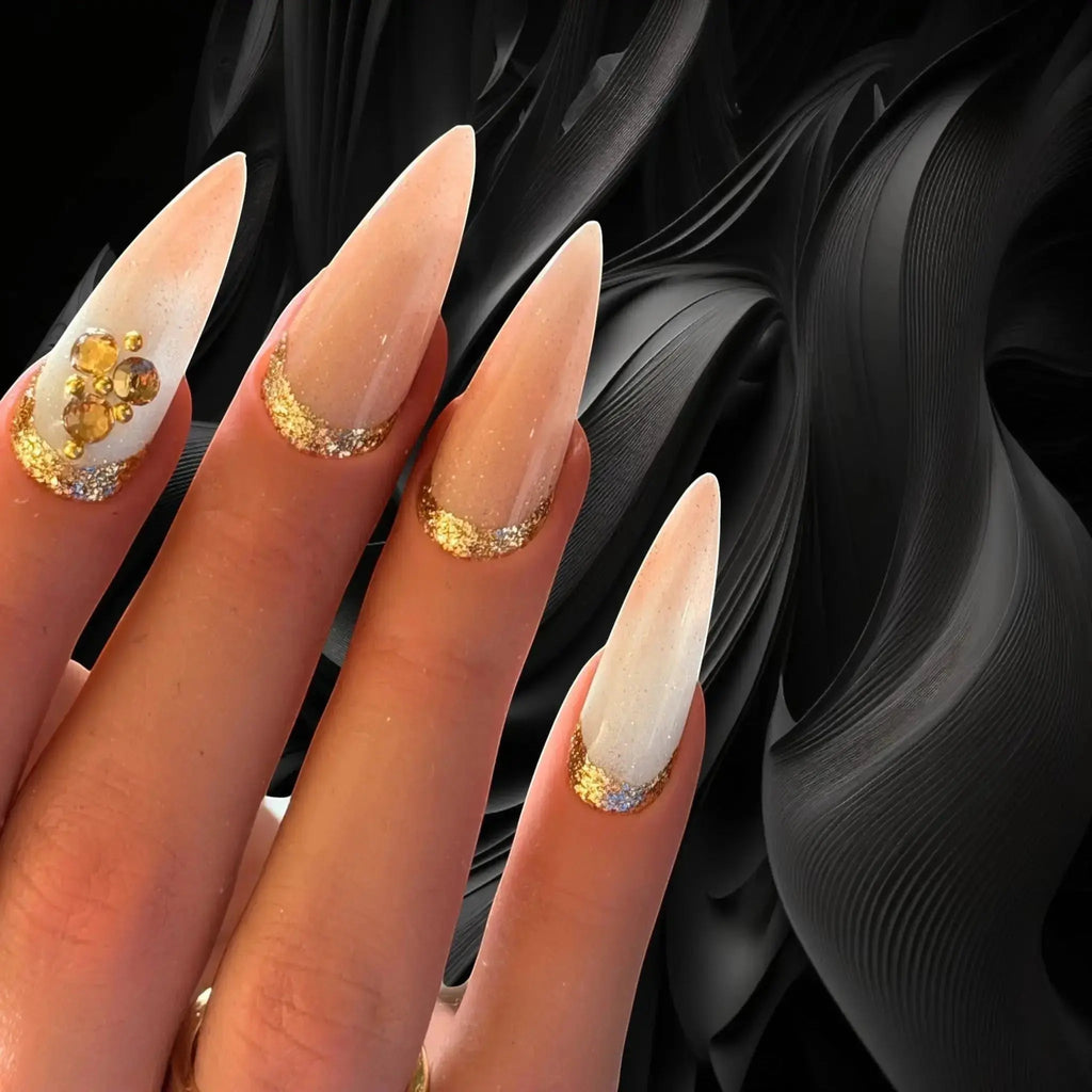 Press to Impress Antigua luxury stiletto press-on nails with champagne shimmer, ivory accents, and gold glitter details.