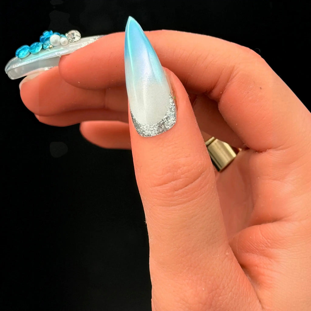 Press to Impress Aruba press-on nail with blue ombre, pearlescent white, silver glitter tip, and 3D floral accents.