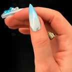Press to Impress Aruba press-on nail with blue ombre, pearlescent white, silver glitter tip, and 3D floral accents.