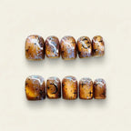 Press to Impress Celestial Amber press-on nails with hand-painted stars, moons, and metallic accents on a warm amber base.