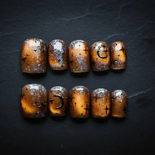 Press to Impress Celestial Amber press-on nails with hand-painted stars, moons, and cosmic shimmer.