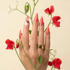 Press to Impress Saint Lucia coral-red stiletto press-on nails with gold accents and crystal embellishments.