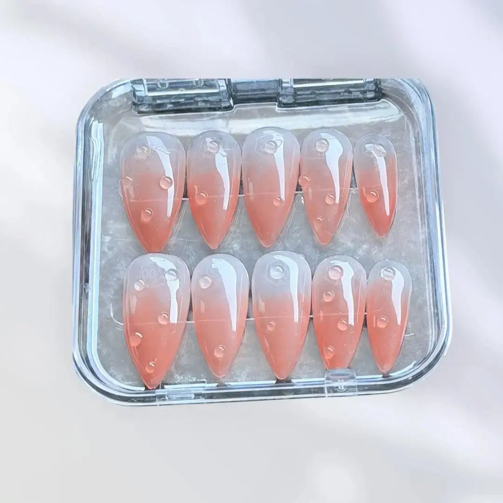 Press to Impress Dew Kiss peachy nude almond press-on nails with glossy water droplet accents.