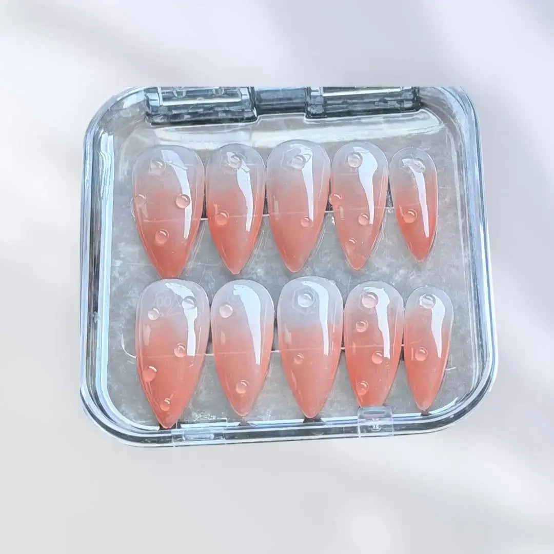 Press to Impress Dew Kiss peachy nude almond press-on nails with glossy water droplet accents.