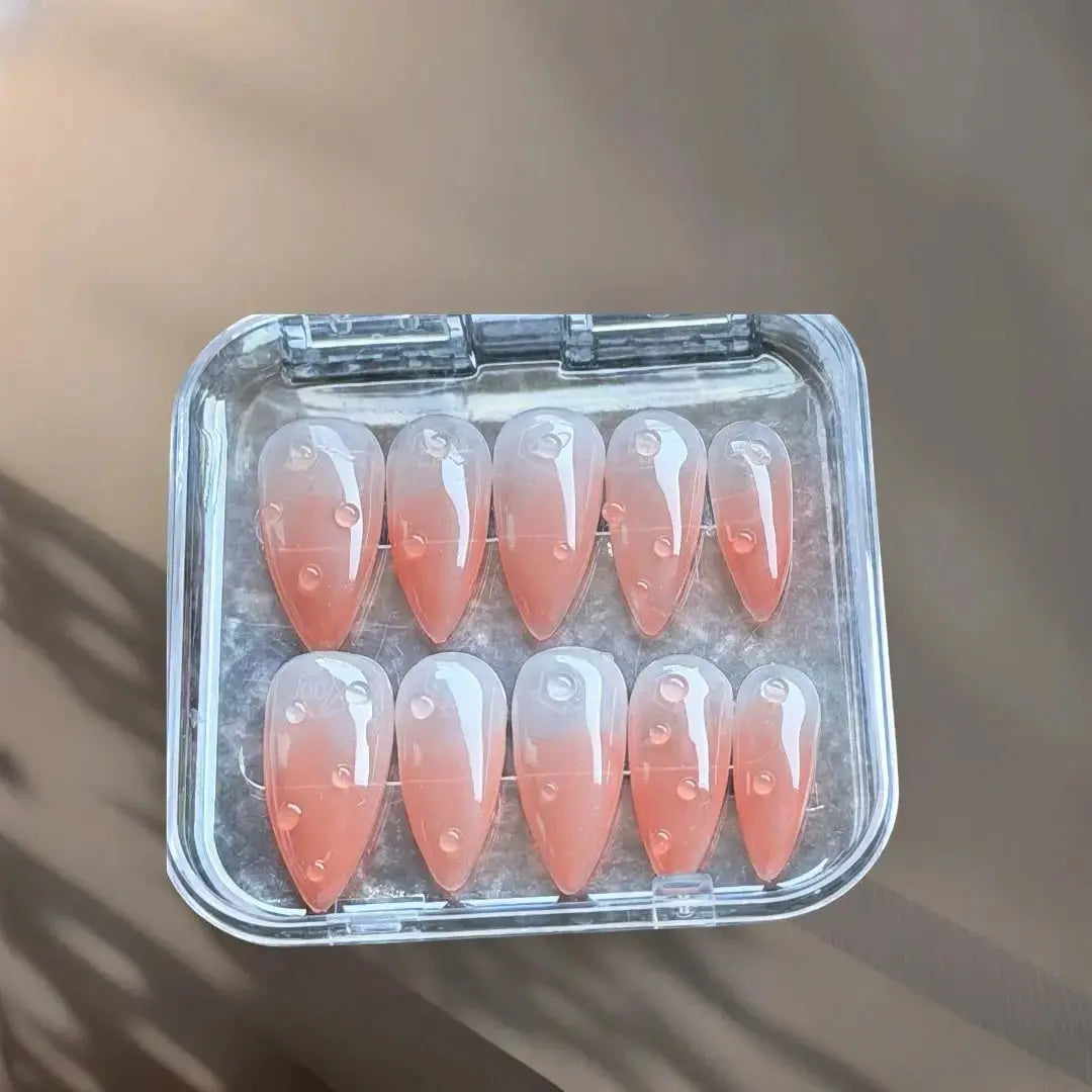 Press to Impress Dew Kiss peachy nude press-on nails with glossy water droplet accents and a glossy finish.