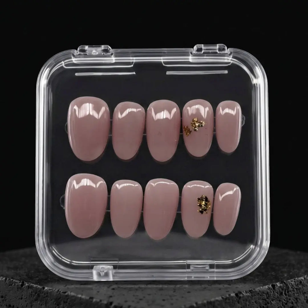 Press to Impress Gilded Whisper short round press on nails in soft pink nude with gold flakes. Reusable and chic.