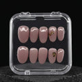 Press to Impress Gilded Whisper short round press on nails in soft pink nude with gold flakes. Reusable and chic.