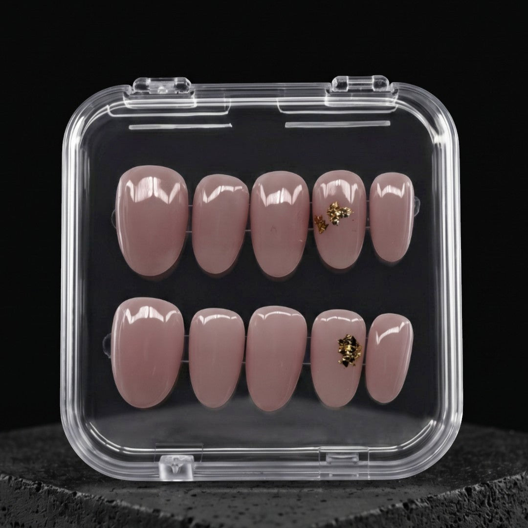 Press to Impress Gilded Whisper short round press on nails in soft pink nude with gold flakes. Reusable and chic.