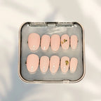 Press to Impress Gilded Whisper short round press on nails in soft pink nude with gold flakes.