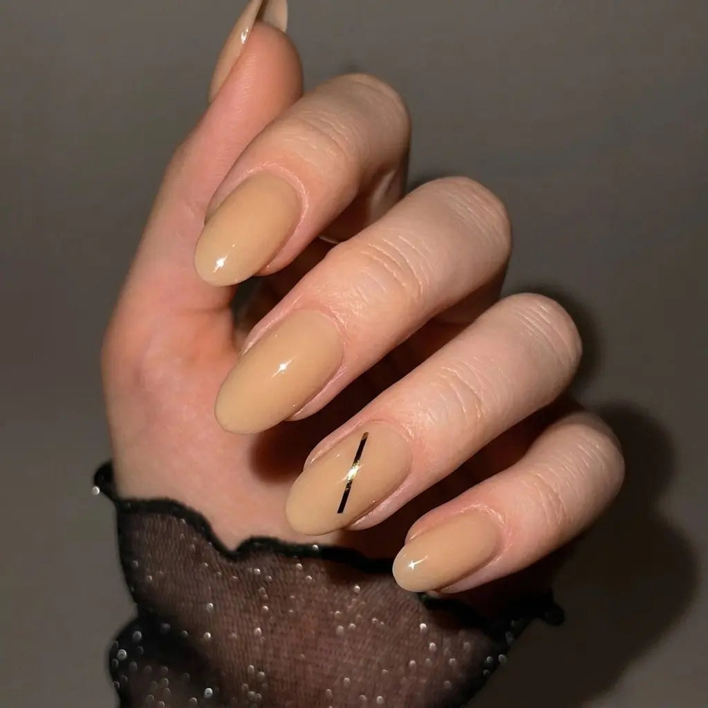 Press to Impress Golden Hour Beige short round press-on nails with a gold line accent. Clean girl aesthetic.