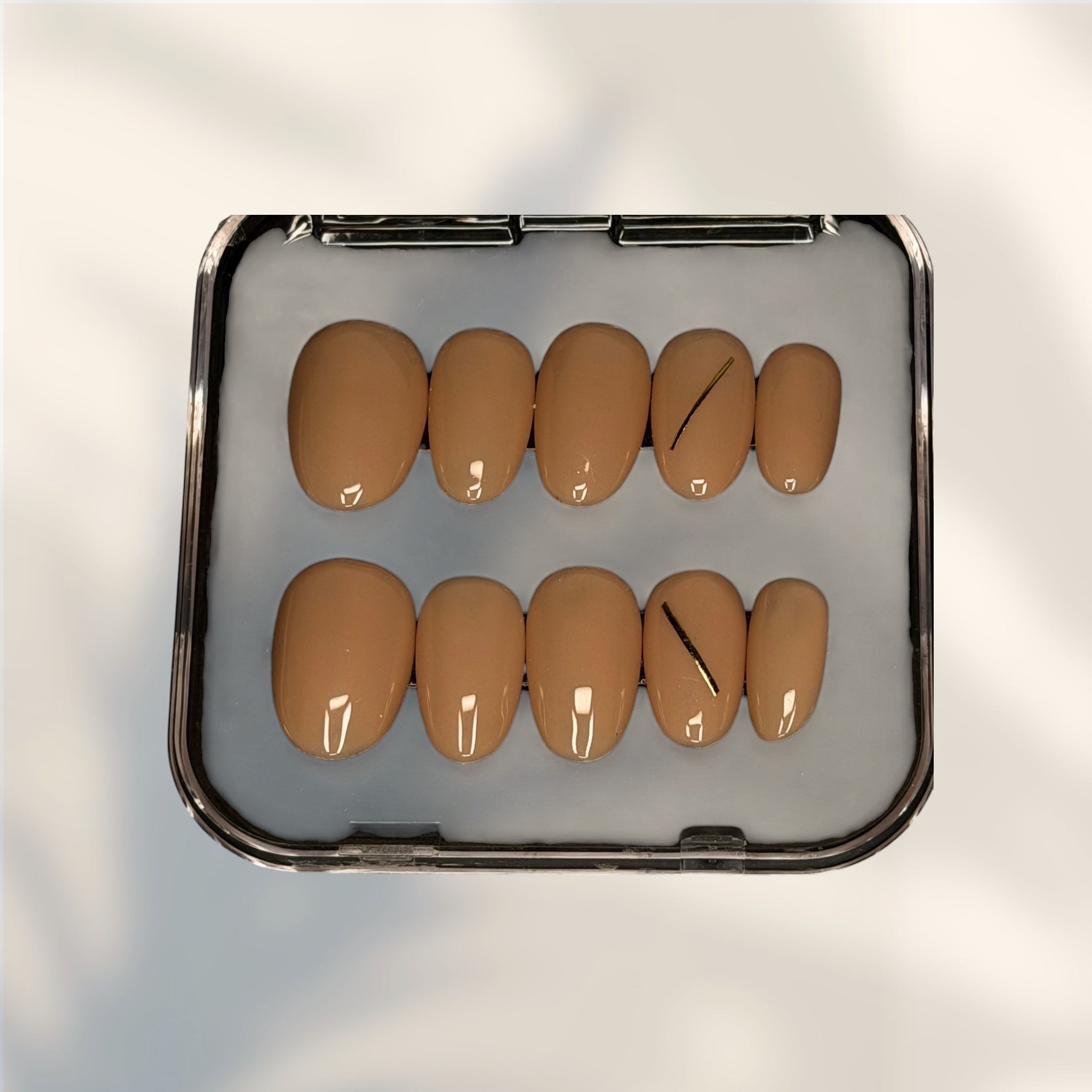 Press to Impress Golden Hour Beige short round press-on nails with a gold line accent. Set of 10.