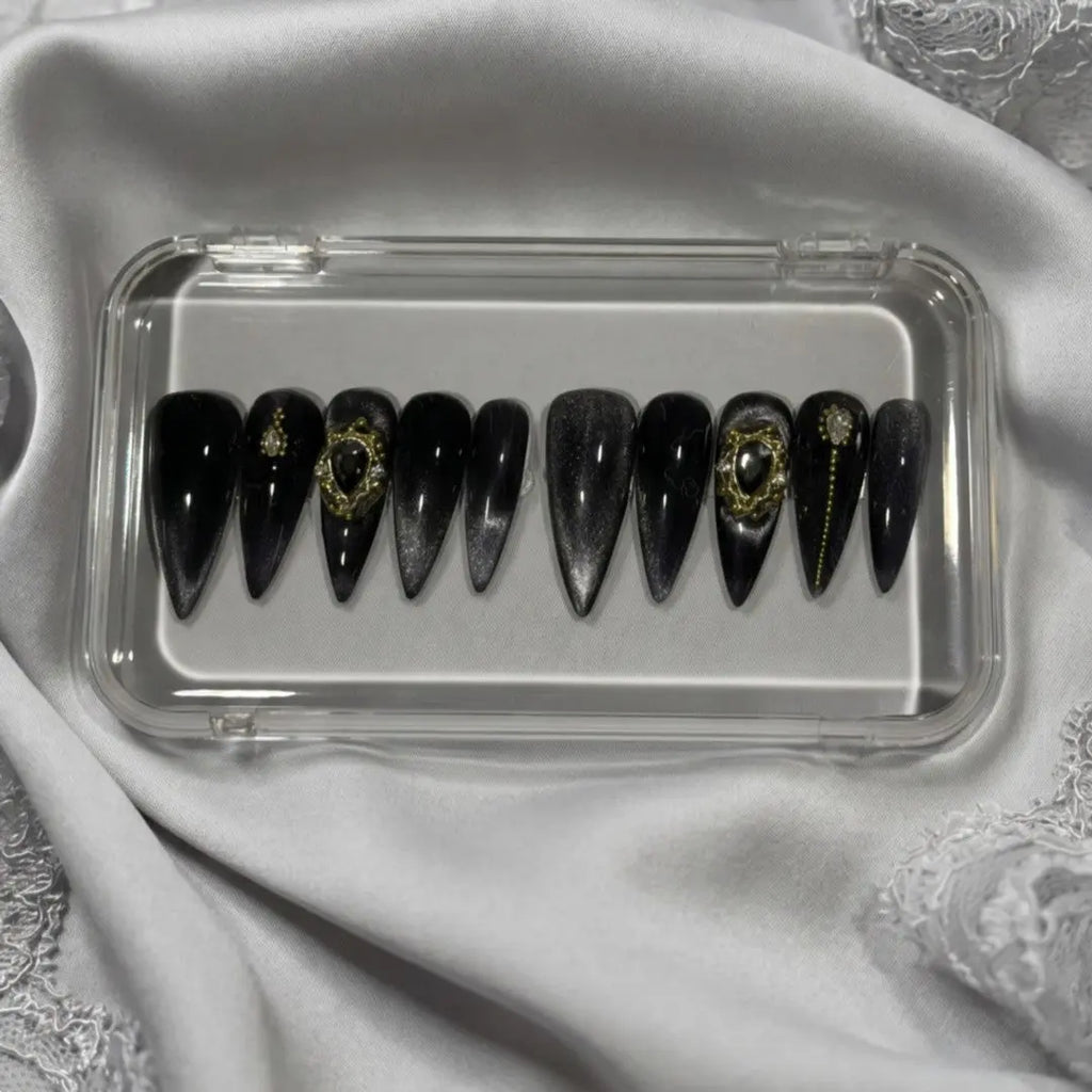 Press to Impress Golden Obsidian luxury press on nails, black with gold accents and cat-eye effect. Stiletto shape.