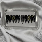 Press to Impress Golden Obsidian luxury press on nails, black with gold accents and cat-eye effect. Stiletto shape.