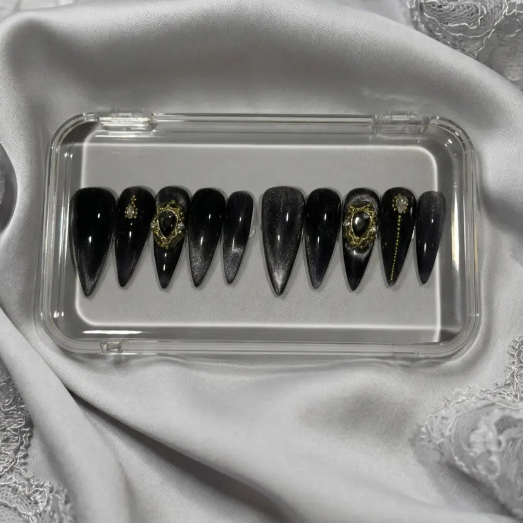 Press to Impress Golden Obsidian luxury press on nails, black with gold accents and cat-eye effect. Stiletto shape.