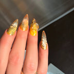 Press to Impress Golden Safari press-on nails with amber glass French tips, animal print, and gold chain accents.