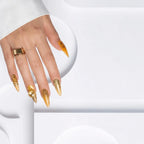 Press to Impress Golden Safari press-on nails with amber French tips, animal print, and gold 3D accents on a hand.