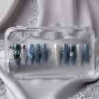 Press to Impress Midnight Spell press on nails feature a mix of midnight blue, holographic, and lace designs. Stiletto shape.