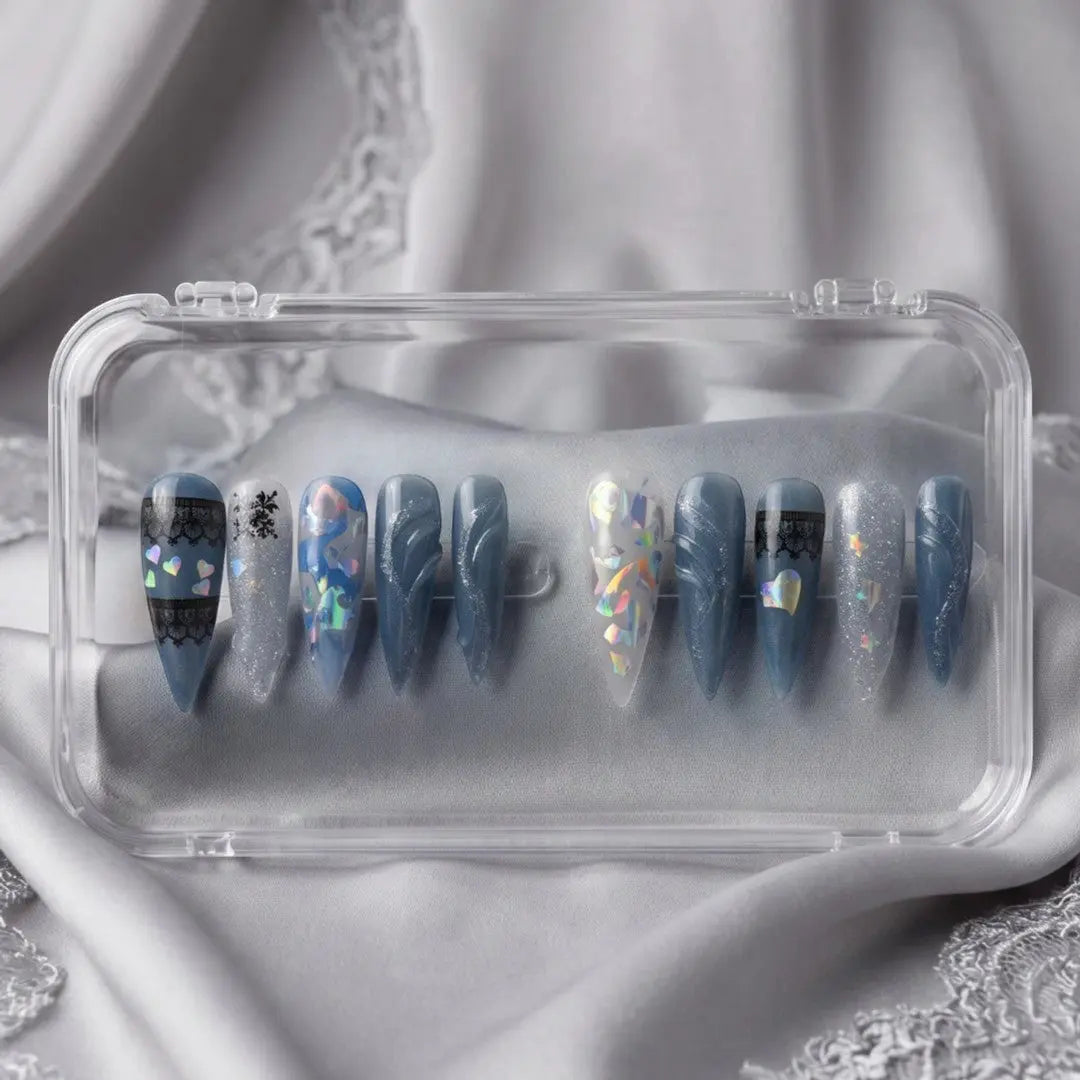Press to Impress Midnight Spell press on nails feature a mix of midnight blue, holographic, and lace designs. Stiletto shape.
