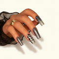Press to Impress Midnight Stardust long square nails with black micro-glitter, silver sparkle, and star details.