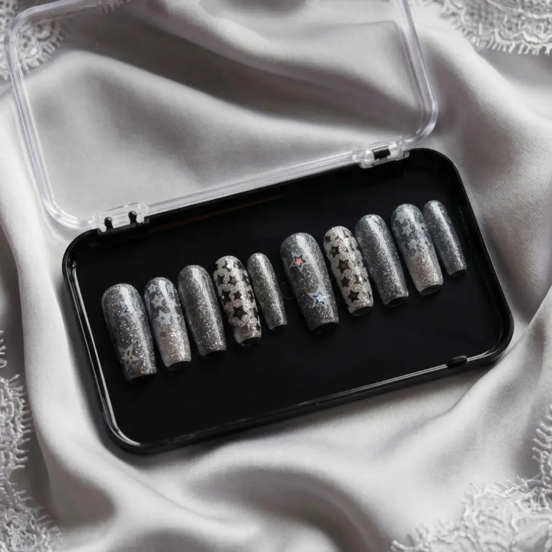 Press to Impress Midnight Stardust long square press-on nails with black micro-glitter and silver star accents.