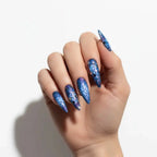 Press to Impress Mystic Galaxy stiletto press-on nails in midnight blue with violet undertones and glitter.