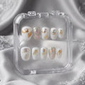 Press to Impress Opaline Reverie press-on nails: milky white with gold foil and iridescent accents, velvety finish.