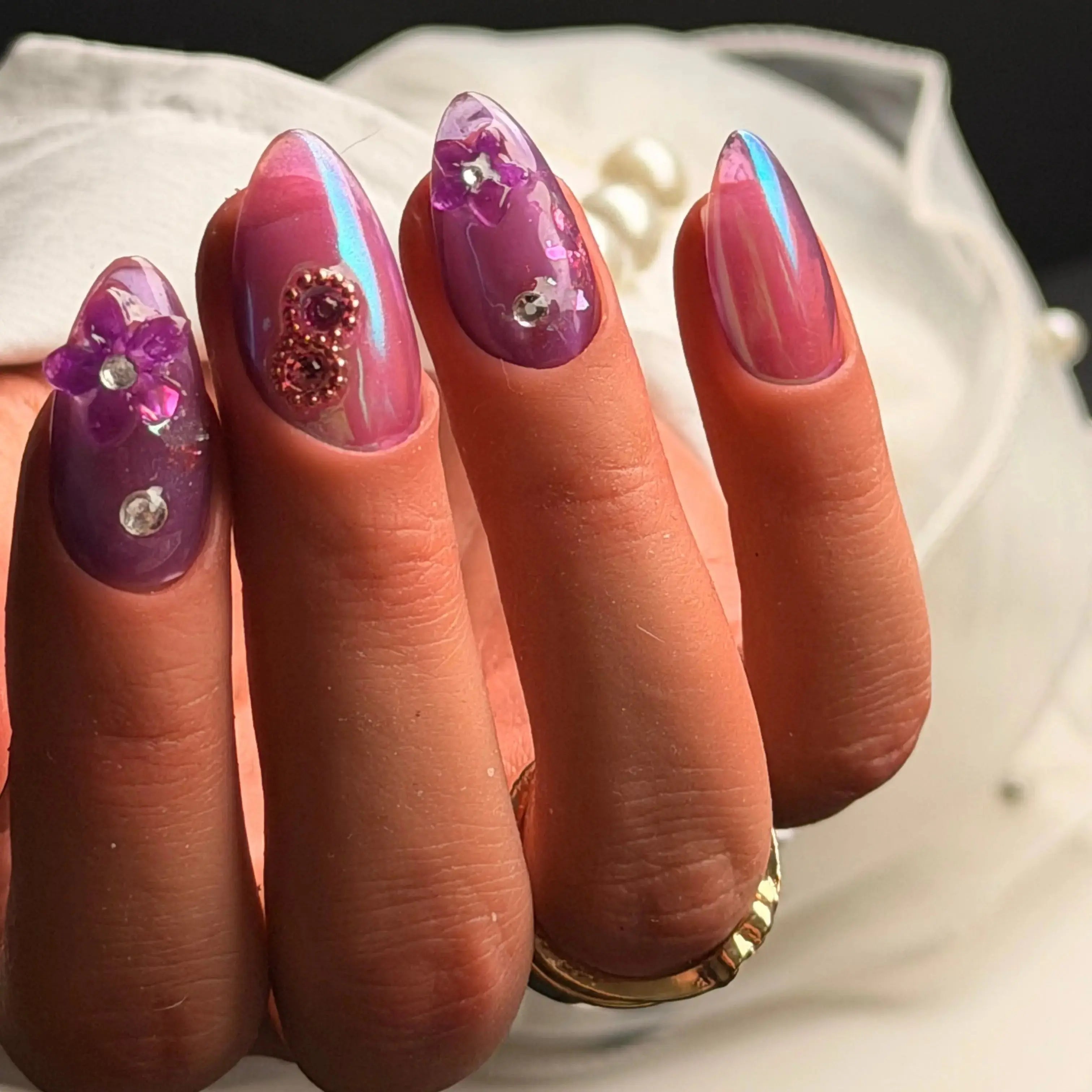 Press to Impress Orchid Mirage iridescent chrome nails with sculpted florals, crystals, and violet hues.