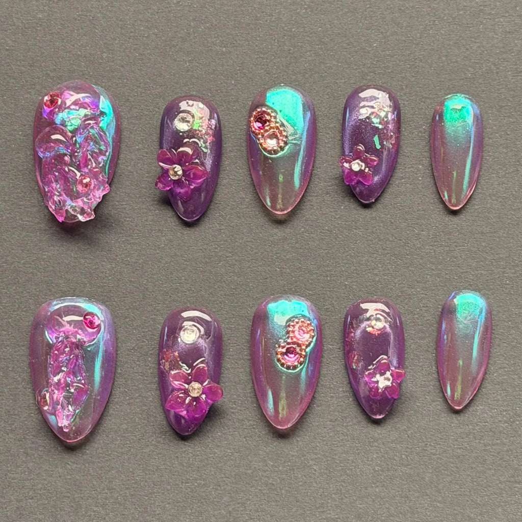 Press to Impress Orchid Mirage iridescent chrome press-on nails with sculpted florals and crystal embellishments in violet hues.