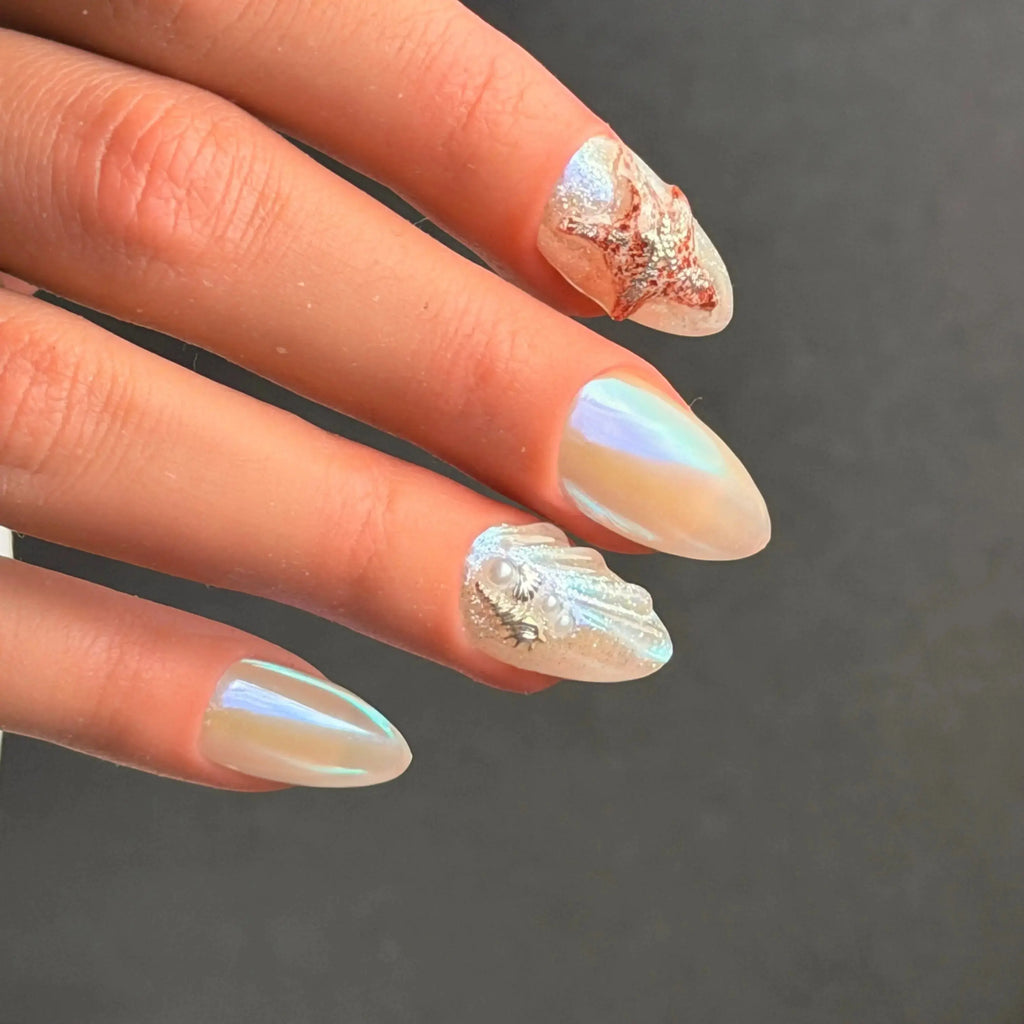 Press to Impress Pearl Cove iridescent almond nails with shell and pearl accents.