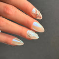 Press to Impress Pearl Cove iridescent almond nails with shell and pearl accents.