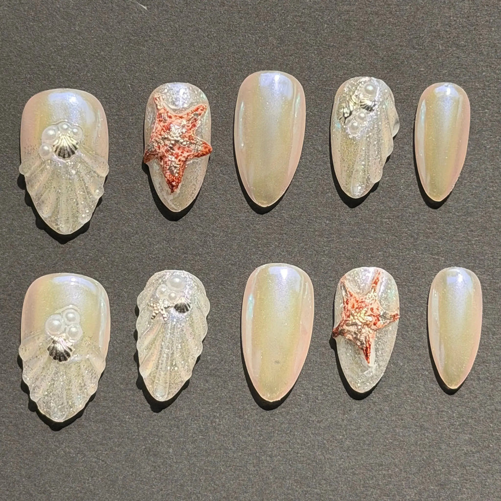 Press to Impress Pearl Cove iridescent pearl and seashell press-on nails with starfish accents.