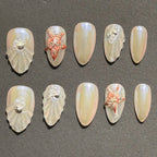 Press to Impress Pearl Cove iridescent pearl and seashell press-on nails with starfish accents.