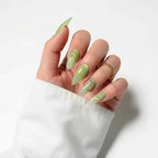 Press to Impress Pistachio Veil stiletto nails with luminous shimmer and translucent detailing, featuring a glossy finish and subtle embellishments.