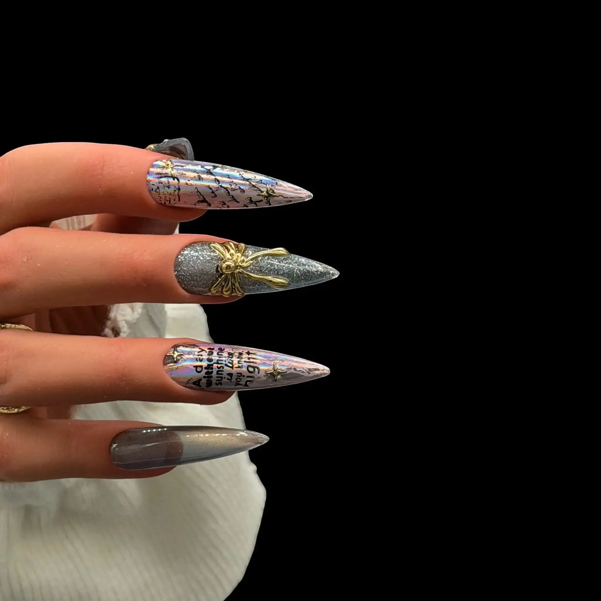 Press to Impress Prism Eclipse stiletto press-on nails with holographic foil, chrome accents, gold embellishments, and text.