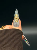 Press to Impress Prism Eclipse stiletto press-on nails with silver glitter, holographic foil, and gold cross embellishment.