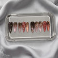 Press to Impress Rose of Shadows luxury press on nails in burgundy, pink, and rose gold with gold floral accents.