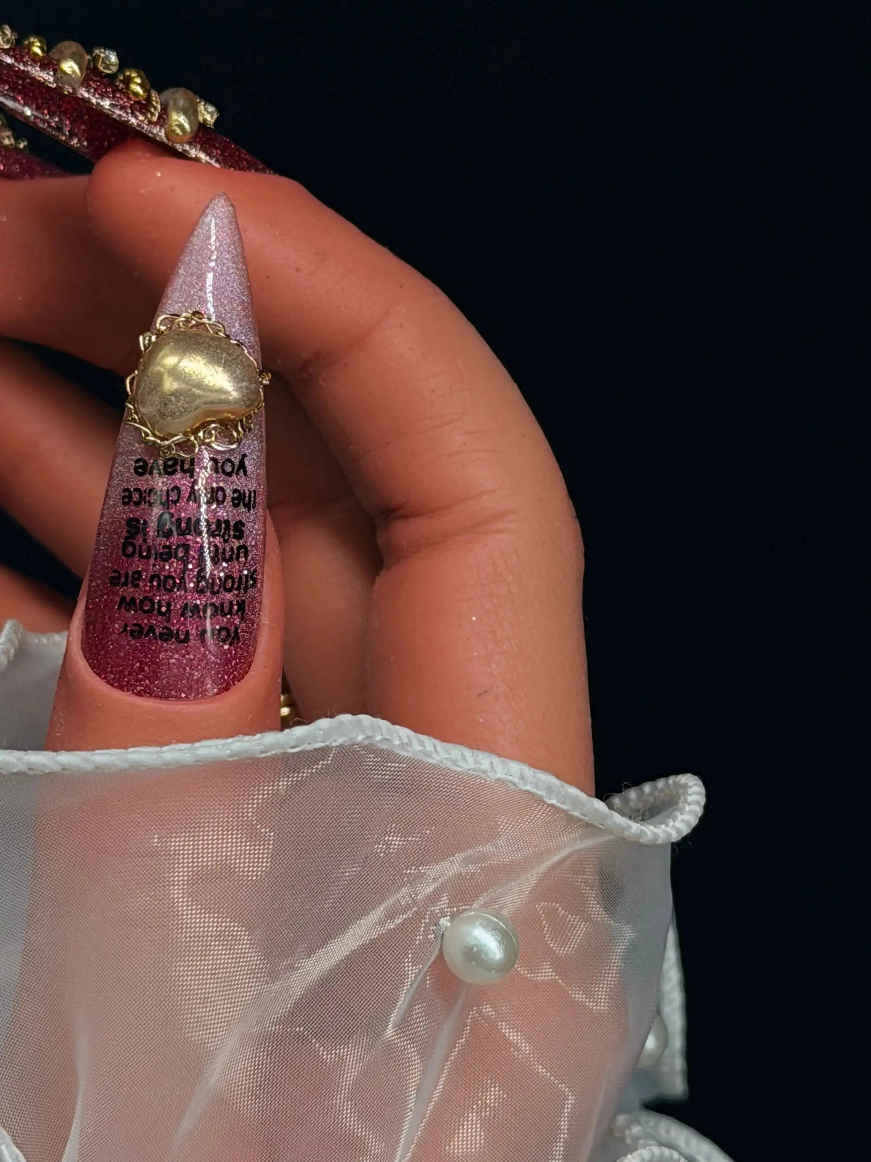 Press to Impress Rouge Sculpt stiletto press-on nails with pink glitter, gold heart, and black text.